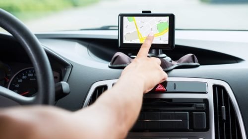 Close-up Of Female's Hand Using GPS Navigation Inside Car